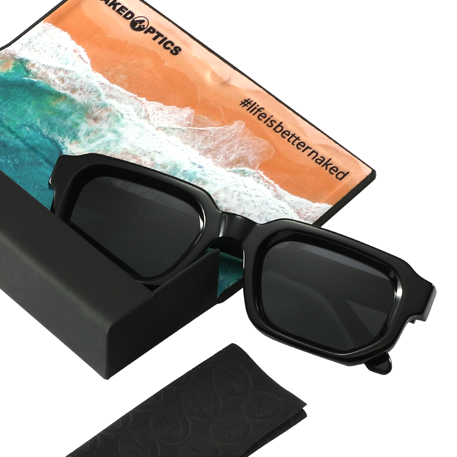 Introducing The IRIS by NAKED Optics: black sunglasses in a case, complete with a beach-themed cloth featuring the #lifeisbetternaked text. Designed with polarized lenses and UV400 protection for ultimate eye safety.