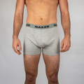 Un homme portant un boxer gris de la marque NAKED Optics, avec un logo sur la ceinture.