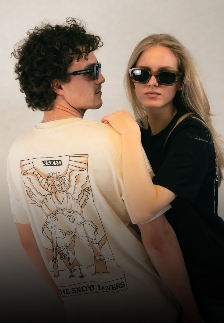 Zwei Personen mit Sonnenbrillen posieren gemeinsam; eine von ihnen trägt ein T-Shirt mit der Aufschrift „The Snow Lovers“...
