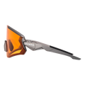 Side view of the futuristic The FALCON sport sunglasses by NAKED Optics, featuring orange lenses, a gray frame with the NAKED Optics logo, and offering UV400 protection.