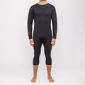 Ein Mann steht barfuß vor einem weißen Hintergrund und trägt ein dunkles Langarmshirt sowie kurze Leggings, die die nahtlose Thermo-Unterwäsche für Herren (100 % Merino) von NAKED Optics zur Geltung bringen. Diese feuchtigkeitsableitende Merino-Funktionswäsche bietet außergewöhnlichen Komfort und Wärme und eignet sich daher ideal zum Kombinieren in den kälteren Monaten.