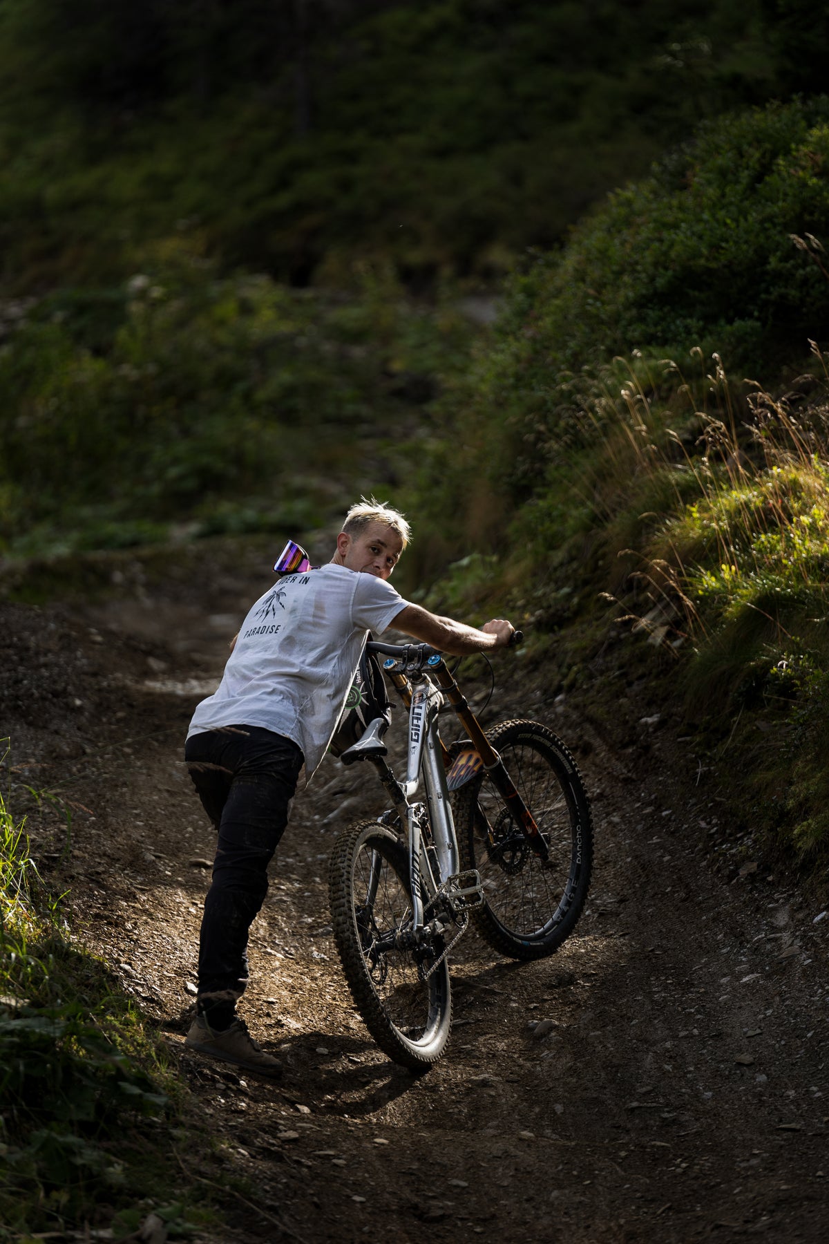 Stevie Schneider Bike Hacks: Stevie Schneider schiebt sein Bike einen Trail hinauf. 