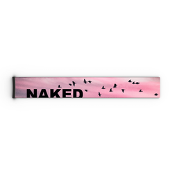 Ein rosafarbener Himmel mit fliegenden Vögeln und dem auffälligen schwarzen Schriftzug „NAKED“ auf einem rechteckigen Objekt – eine Anspielung auf das markante Design, das häufig auf einem NAKED Optics Extra Strap (45 mm) für FORCE EVO, TROOP EVO, STORM, NOVA, SOLAR oder ZEND zu finden ist.