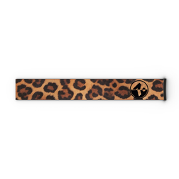 Ein rechteckiges Extra-Band (45 mm) mit Leopardenmuster, entworfen für die Skibrillen FORCE EVO, TROOP EVO, STORM, NOVA, SOLAR und ZEND von NAKED Optics, mit einem schwarzen, runden Logo auf der rechten Seite.