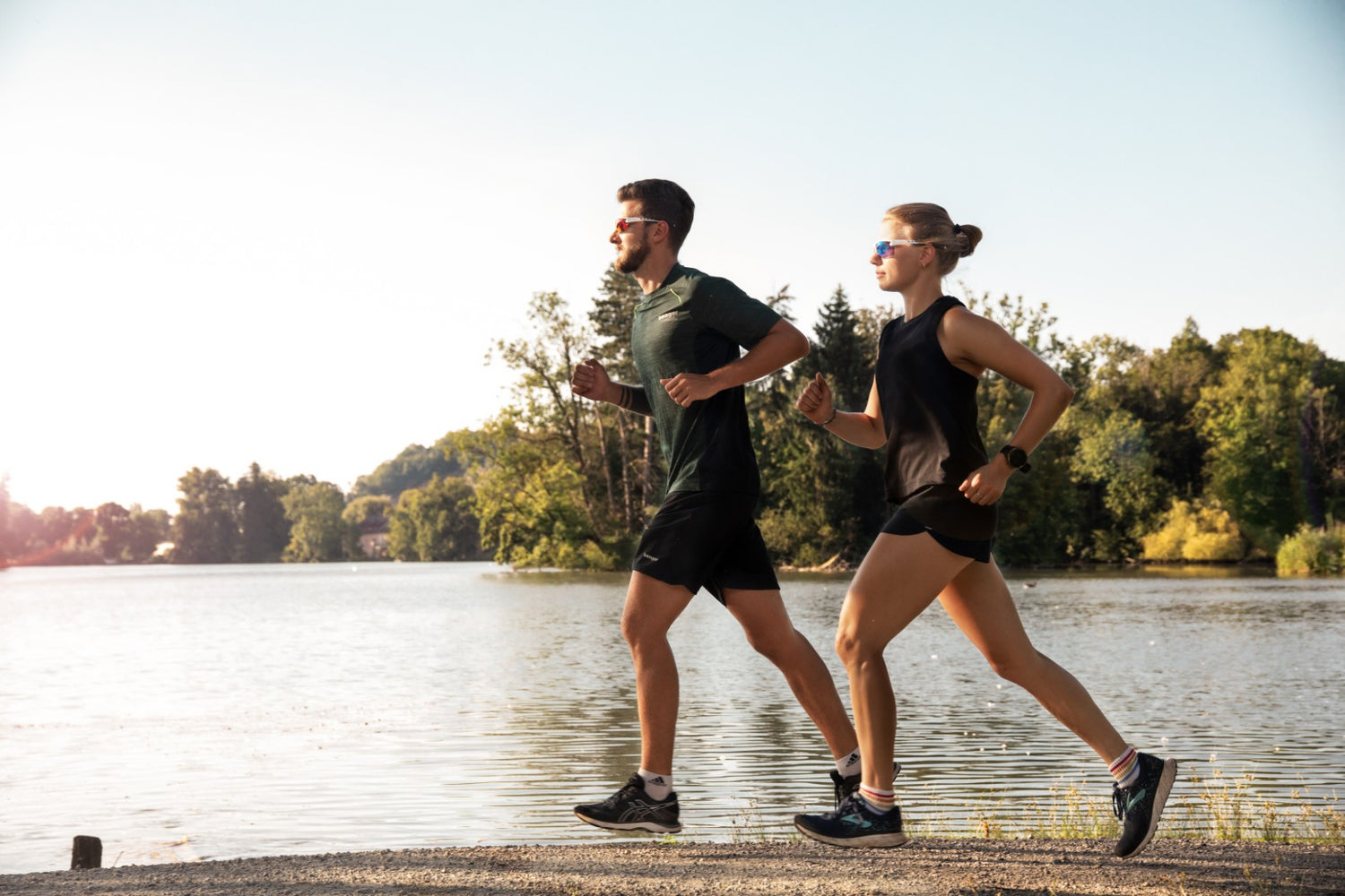 Ein junges Paar läuft an einem See entlang und trägt dabei bunte Sportbrillen; Credits: Florian Dorn