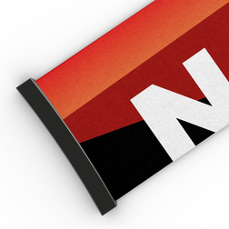 Ein aufgerolltes Banner mit roten, orangefarbenen und schwarzen diagonalen Streifen und einem großen weißen „N“ – das an das markante Design eines 45-mm-Extra-Armbands aus der FORCE EVO-Kollektion von NAKED Optics erinnert.