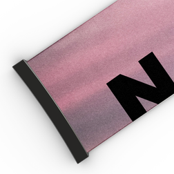 Eine Yogamatte mit einem Farbverlauf in Rosa und Lila, einem schwarzen Rand und einem auffälligen schwarzen „N“, die den dynamischen Stil des Extra-Riemens (45 mm) für die Modelle FORCE EVO, TROOP EVO, STORM, NOVA, SOLAR und ZEND von NAKED Optics aufgreift.