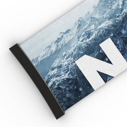 Auf dem Design ist ein aufgerolltes Poster zu sehen, das verschneite Berge und einen großen weißen Buchstaben „N“ zeigt und an die atemberaubenden Ausblicke erinnert, die man durch eine NAKED Optics Extra Strap – FORCE EVO, TROOP EVO, STORM, NOVA, SOLAR, ZEND (45 mm) – erleben kann.