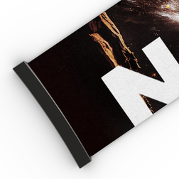Eine Nahaufnahme eines aufgerollten Plakats mit schwarzem Rand, auf dem ein Teil des markanten weißen Buchstabens „N“ vor dunklem Hintergrund zu sehen ist – ganz im Stil des eleganten Designs des „Extra Strap“ (45 mm) von NAKED Optics für die Modelle FORCE EVO, TROOP EVO, STORM, NOVA, SOLAR und ZEND.