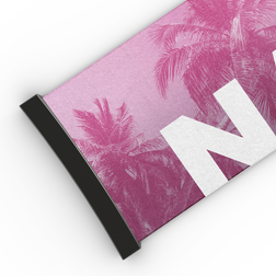 Nahaufnahme eines rosa NAKED Optics Extra-Armbands (45 mm) für die FORCE EVO mit Palmenmuster, schwarzem Rand und auffälligem weißem „N“ – das perfekte Accessoire von Ersatzstraps für Skibrillen.