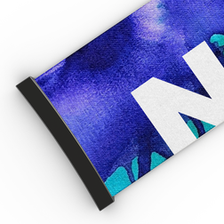 Nahaufnahme eines Stoffbanners mit schwarzem Rand, blau-lila Muster und großem weißen Buchstaben „N“ – ganz im markanten Stil des NAKED Optics Extra Strap (45 mm) für FORCE EVO, TROOP EVO, STORM, NOVA, SOLAR oder ZEND.