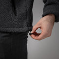 A person tightens the drawcord of a dark gray, wind-resistant Fleece Jacke - Thermiq from NAKED Optics with their right hand.