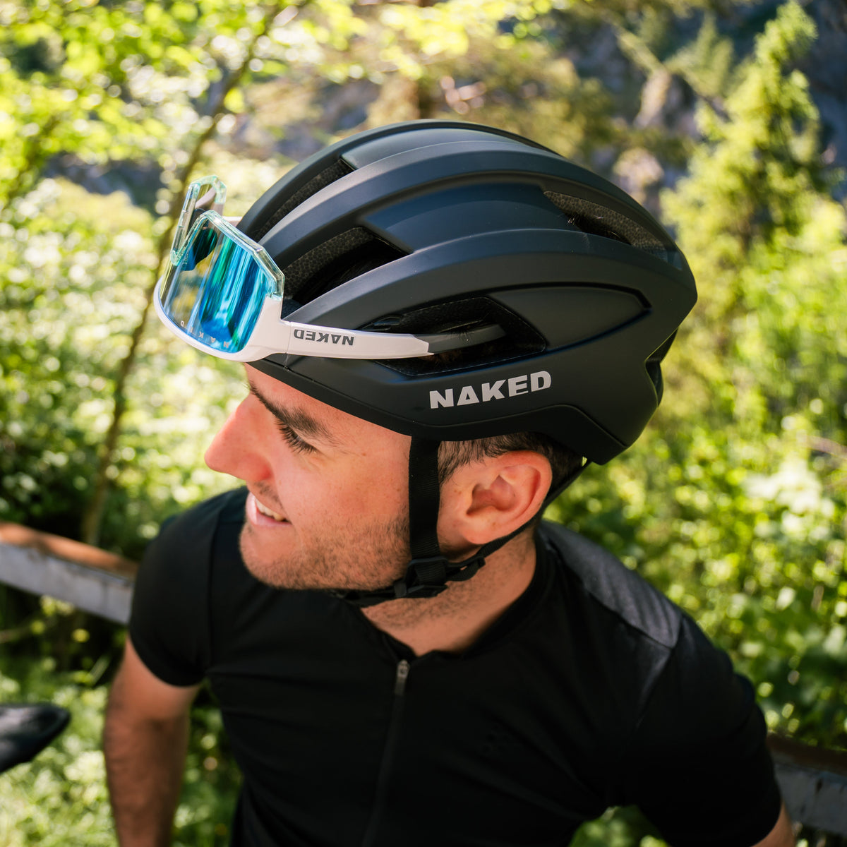 Ein Fahrradfahrer trägt einen Fahrradhelm von NAKED Optics bei dem er eine passende Sportbrille in die Belüftungsschlitze geklemmt hat; Credits: Elias Neier