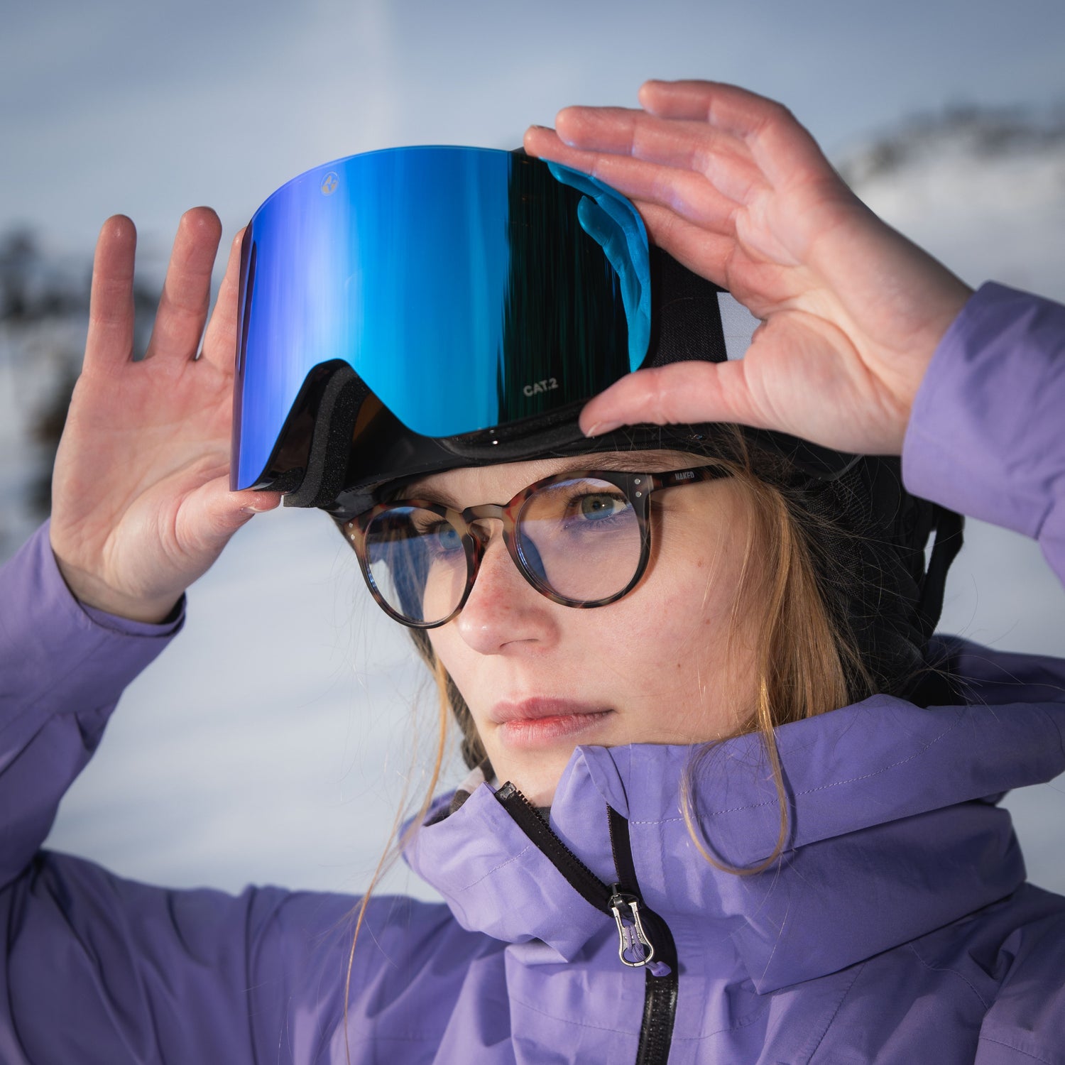 Eine Skifahrerin hebt ihr Skibrille auf den Helm, darunter trägt sie eine Sichtbrille zum Skifahren; Credits: Elias Neier 