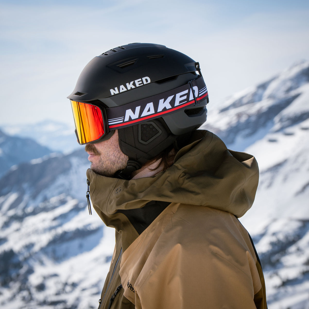 Mann trägt schwarzen Skihelm und eine Skibrille mit orangen Gläsern
