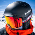 A winter sports athlete wears a black NAKED Optics APEX helmet and mirrored orange goggles.