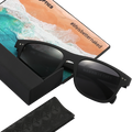 Die SLUSH-Sonnenbrille von NAKED Optics mit schwarzen polarisierten Gläsern, passendem Etui und Reinigungstuch – dazu gibt es eine Postkarte mit Strandmotiv und dem Hashtag #lifeisbetternaked – eignet sich perfekt für Outdoor-Aktivitäten.