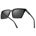 Rectangular black sunglasses with thick frames and dark lenses rest on a light background. The MUSE by NAKED Optics feature UV400 protection and polarized lenses, providing both style and superior eye protection. The brand name NAKED is printed on the arm.