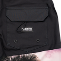 Close-up of a black pocket featuring the NAKED Optics “Life is better Naked” label and a glimpse of tropical tree print, seen on The SHORE Boardshorts—crafted from 4-way stretch material, perfect for surfing or relaxed beach days.