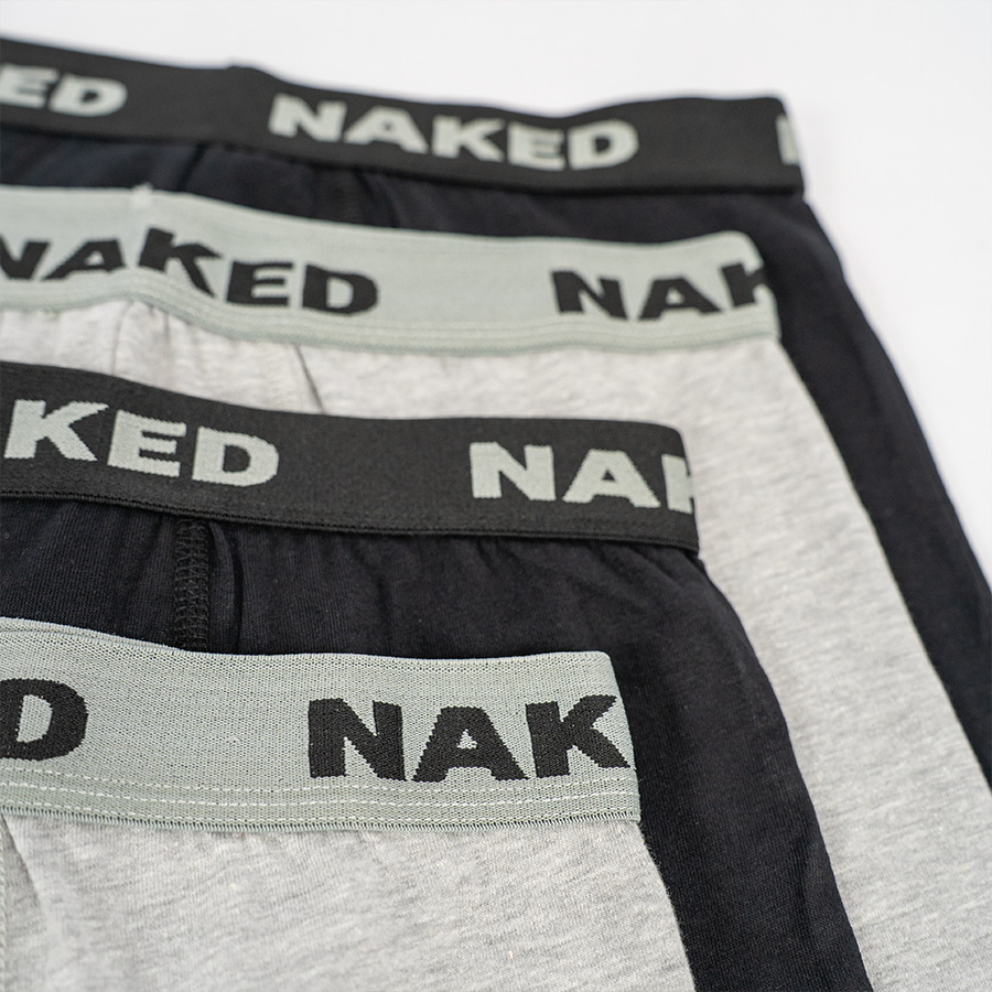 4 Boxershorts liegen übereinander. Sie sind abwechselnd grau und schwarz. Der elastische Bund ist mit einem NAKED Logo bedruckt.
