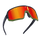Les lunettes de soleil NAKED Optics VOLT Hero-Edition se caractérisent par des verres miroités rouge-orange, une monture noire et une bordure inférieure verte, présentées en perspective sur un fond blanc. Inspirées par Stevie Schneider, ces lunettes de VTT allient un style unique à des performances de haut niveau pour toutes vos sorties.