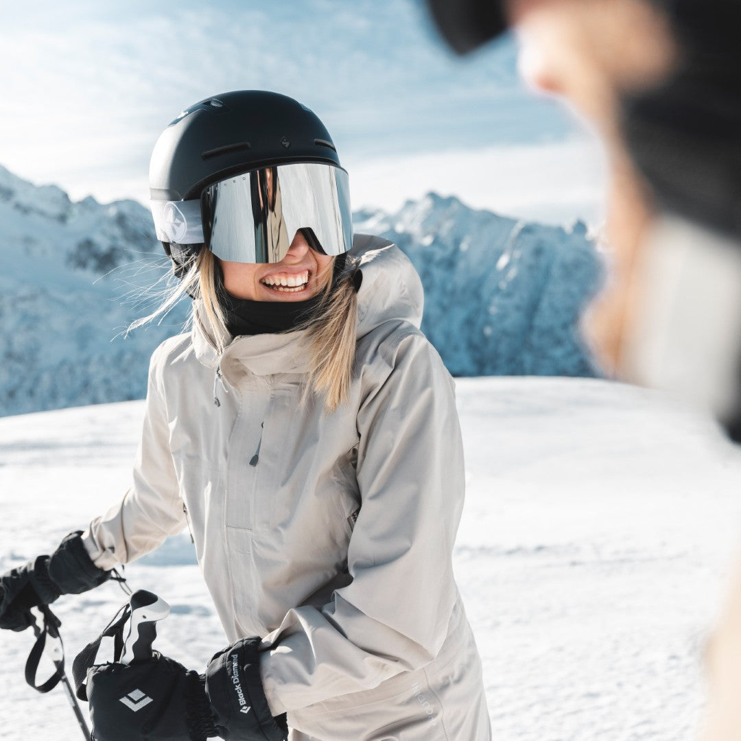 Eine junge Skifahrerin trägt eine große, verspiegelte Skibrille und lacht in die Kamera; Credits: Mathäus Gartner