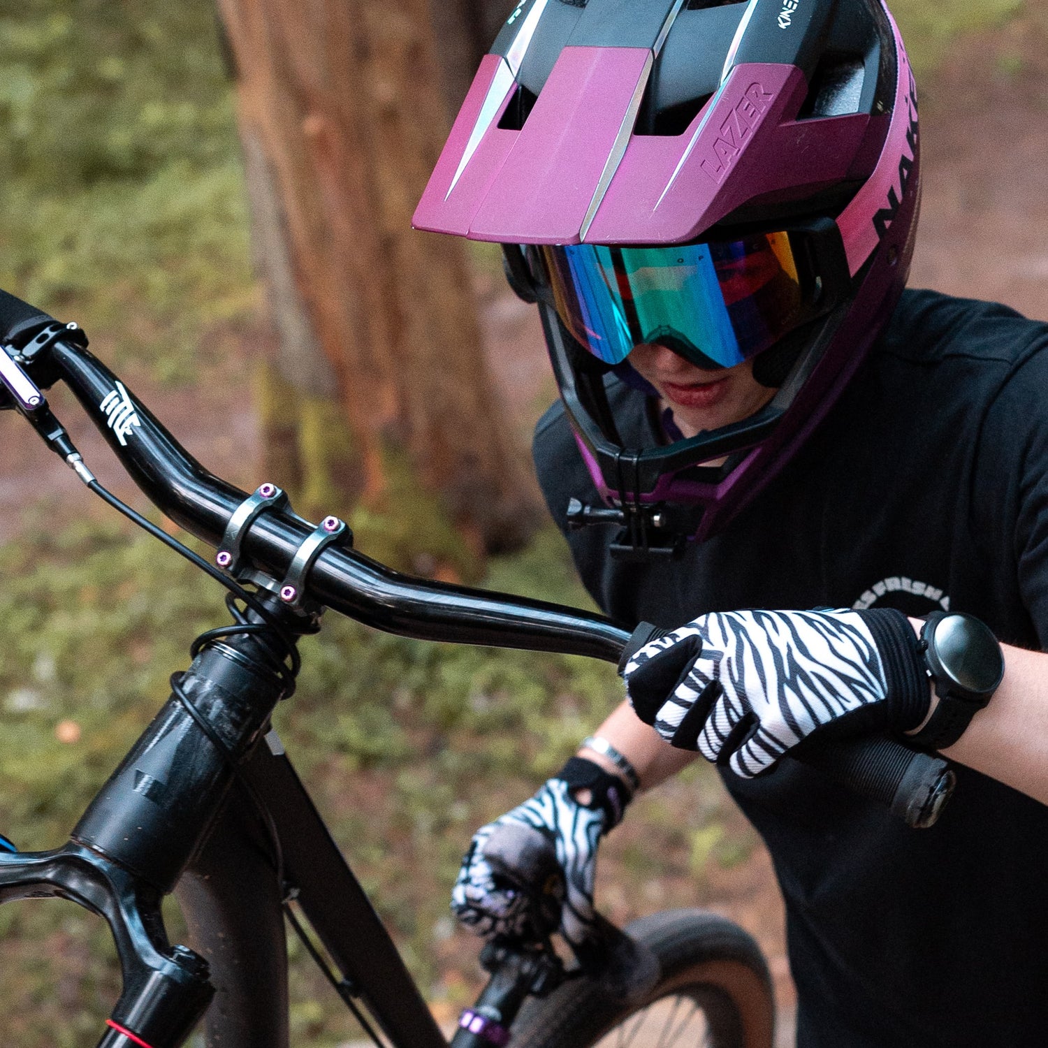 Ein Mountainbiker schiebt sein Rad einen Berg hinauf, er trägt auffällige Bike Handschuhe; Credits: Dmitrijs Krilovs