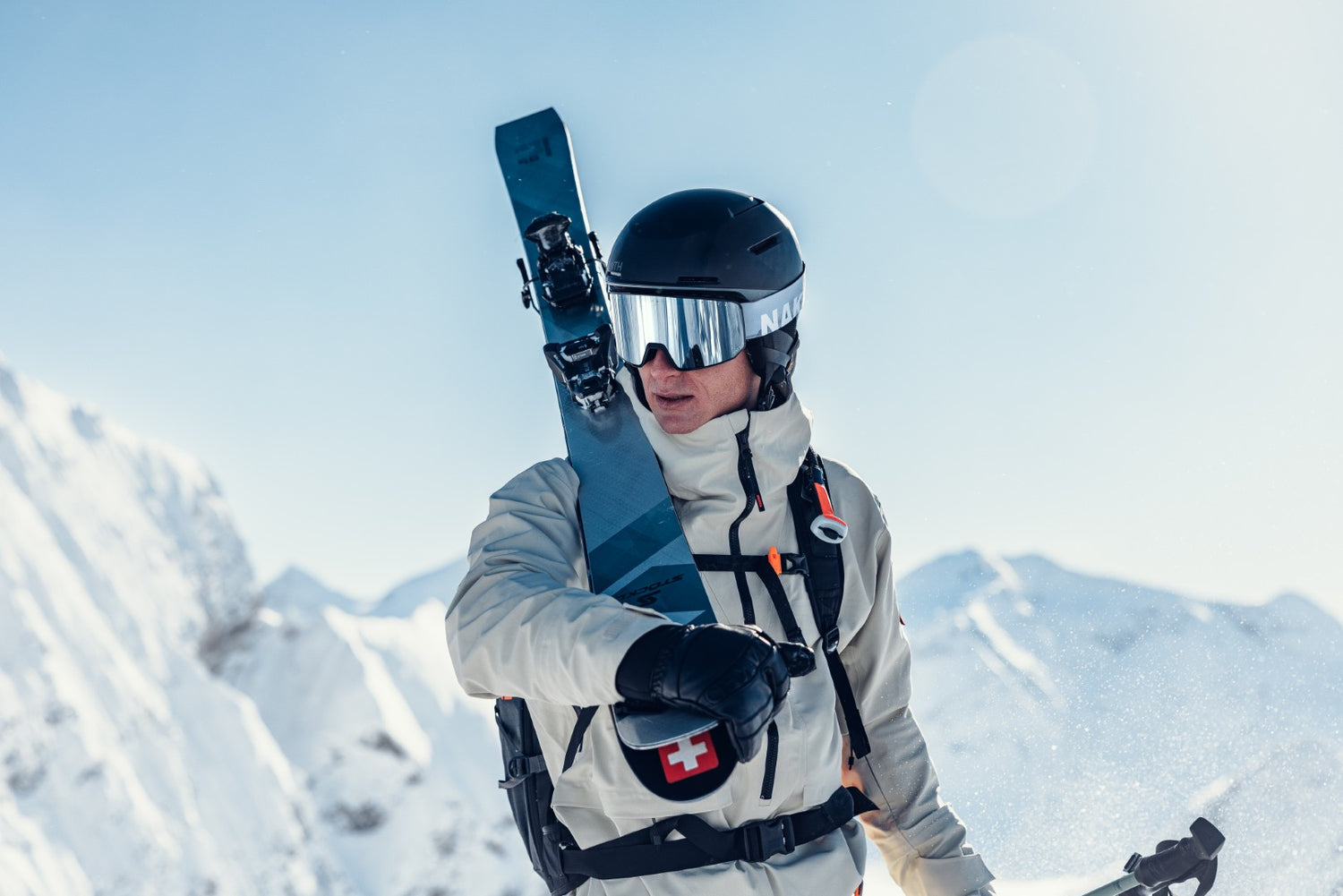 Ein Skifahrer steht mit seinen Ski am Berg und schaut durch seine Skibrille Herren in die Kamera; Credits: Mathäus Gartner