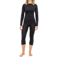 A woman wearing the NAKED Optics Thermo-Unterwäsche Damen (100% Merino) long-sleeve black top and matching cropped leggings, standing barefoot on a white background.