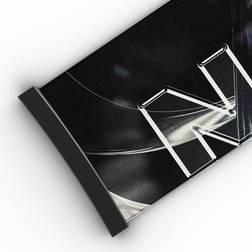 Nahaufnahme eines schwarzen, aufgerollten Posters mit teilweise weißen Schriftzügen auf weißem Hintergrund, das an das schlichte Design des NAKED Optics Extra-Armbands (45 mm) für FORCE EVO, TROOP EVO, STORM, NOVA, SOLAR und ZEND angelehnt ist.