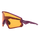 Die lilafarbene Sport-Sonnenbrille von NAKED Optics mit orange getönten Gläsern und dem Schriftzug NAKED" auf dem linken Bügel ist ideal für Outdoor-Aktivitäten und steht auf weißem Hintergrund.