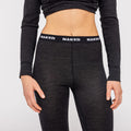 A person is shown from waist to chest wearing a black long-sleeve 100% Merino Thermo-Unterwäsche Damen top and matching pants by NAKED Optics, featuring a waistband with the NAKED logo.